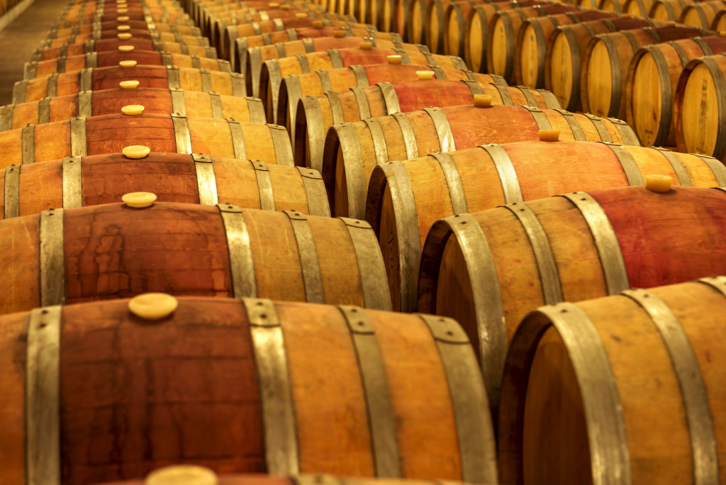 Barrels of wine lined up in a wine cellar.