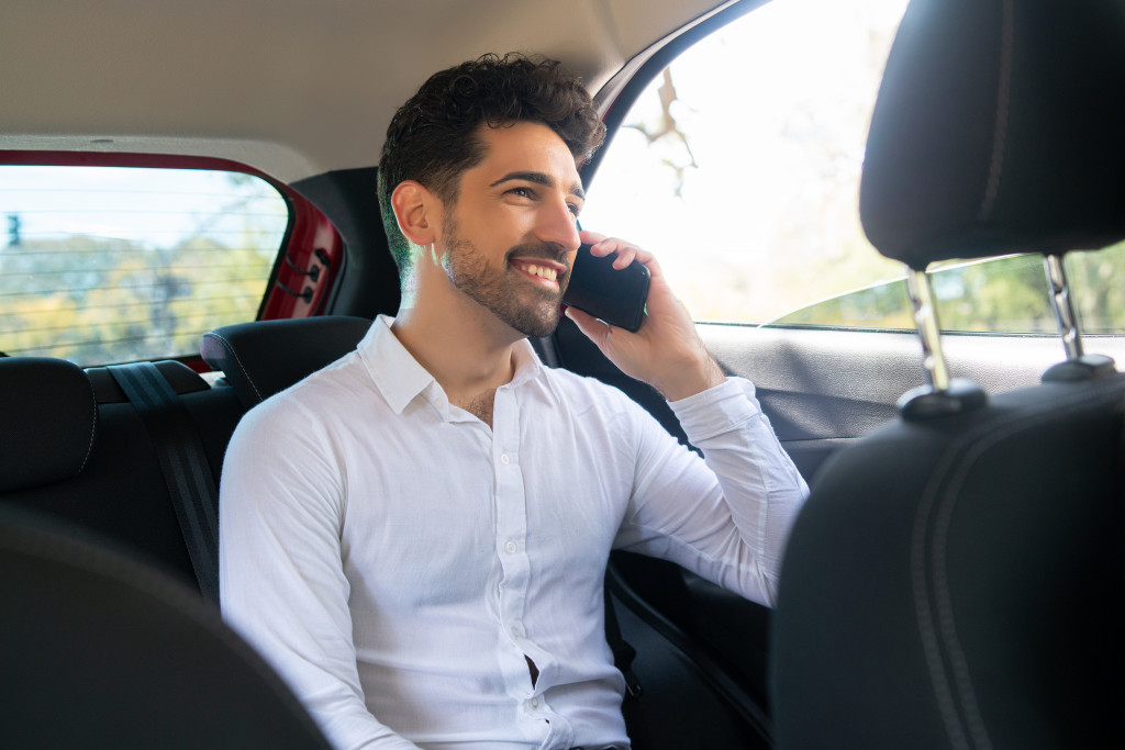 Businessman talking on phone in car.