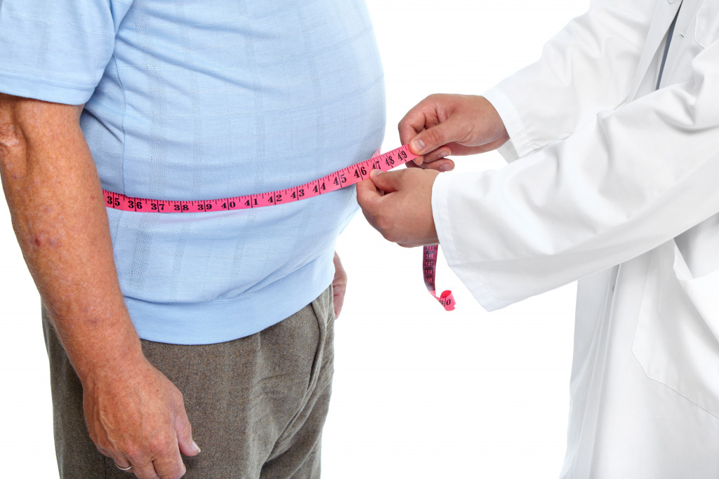 doctor check a man's waistline