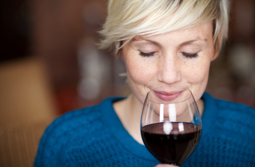 a woman smelling wine