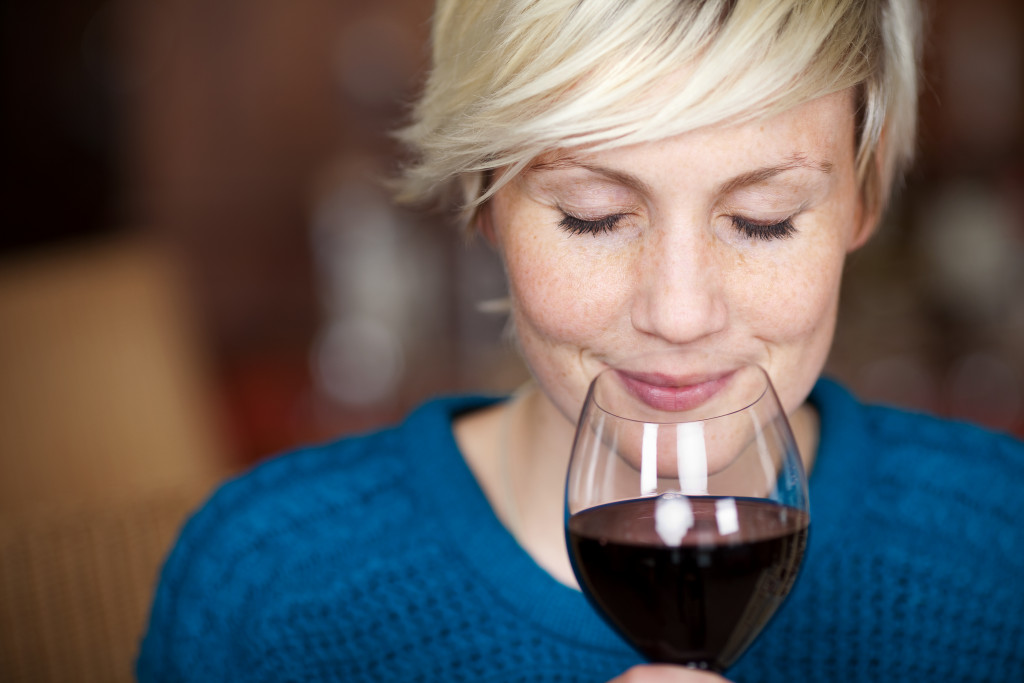 a woman smelling wine