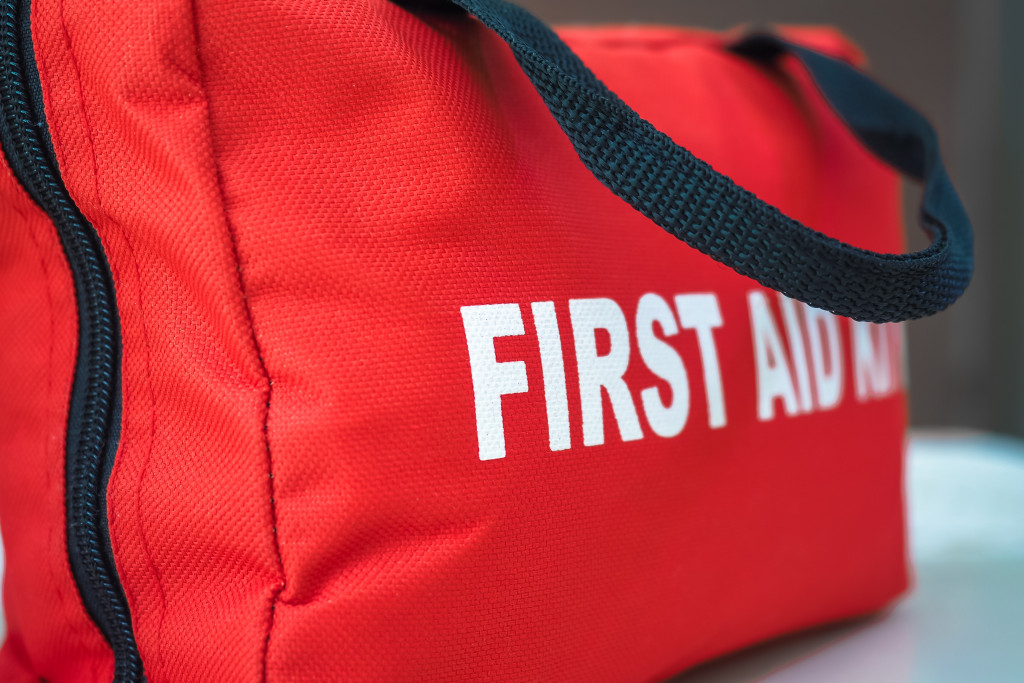 A red first aid kit bag with a handle