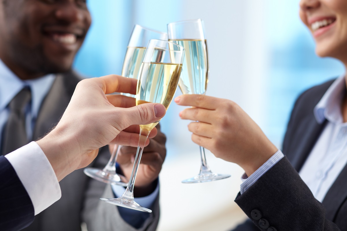 business partners cheering up with flutes of golden champagne