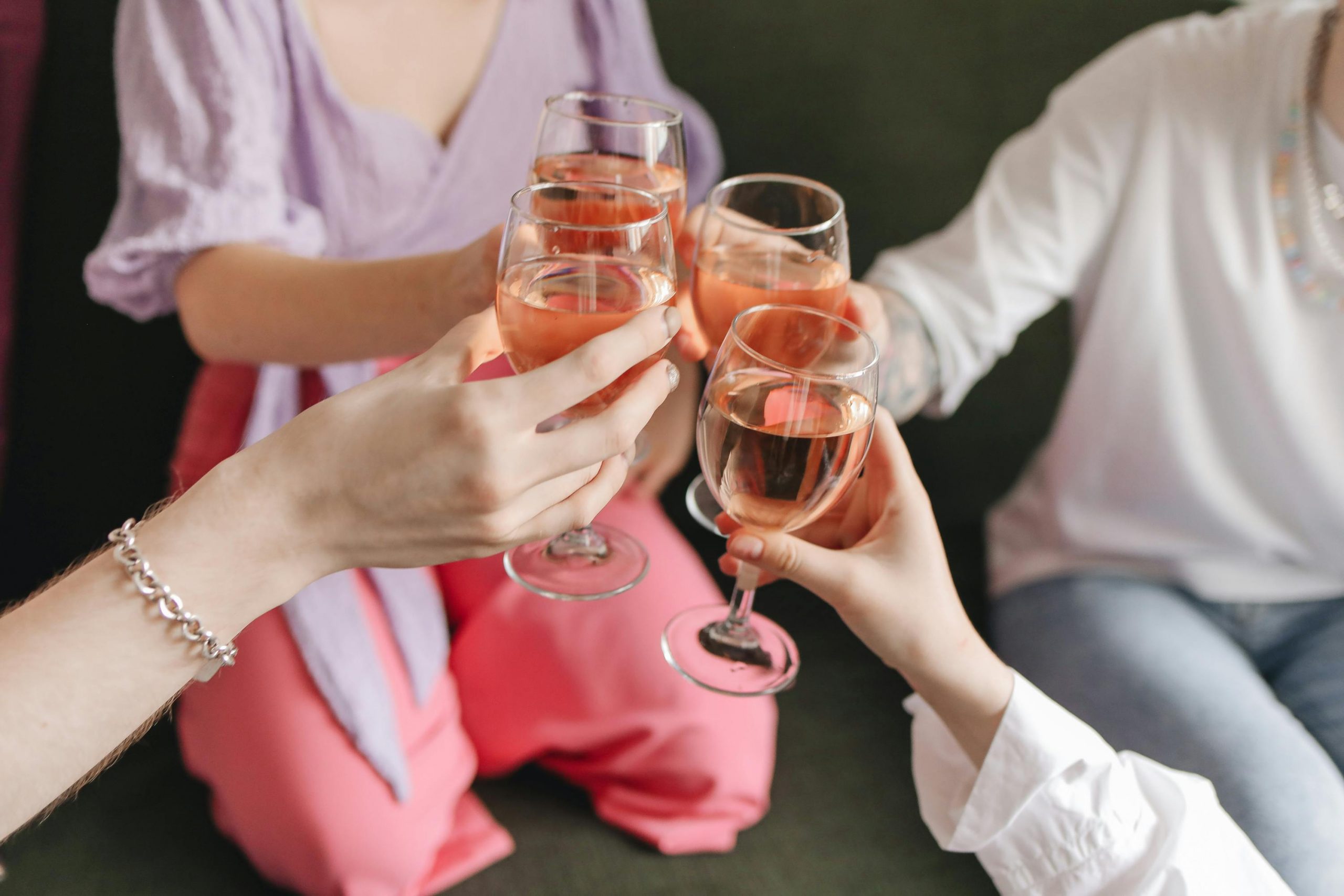 women making a toast with glasses of moscato wine